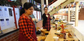 Kulinarische Neuentdeckungen zum Jahresende im Nachbarschaftstreff Am Büfett: vorn die 2. Vorsitzende vom Verein „Schönes Mittelfeld (SchMitt) Kamaly Sandran