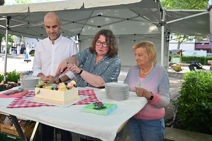 Oberbürgermeister Belit Onay, Wirtschafts- und Umweltdezernentin Anja Ritschel und die stellv. Bezirksbürgermeisterin Gabi Jakob (v.l.) schneiden die Geburtstagstorte an.